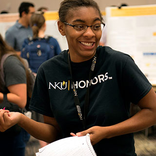 Male student looking into a microscope.