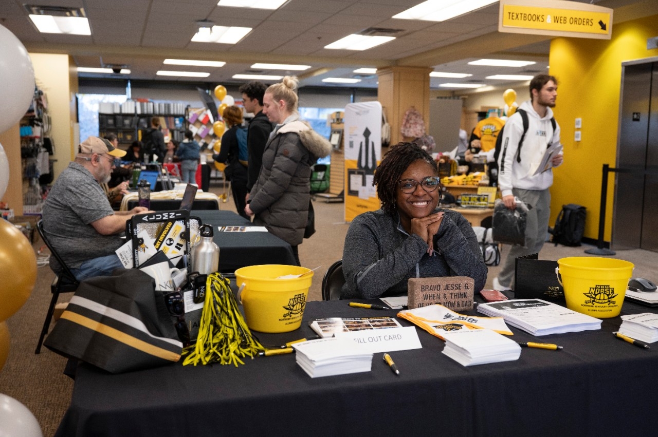 Woman smiling as she greets students at Graduation Fair