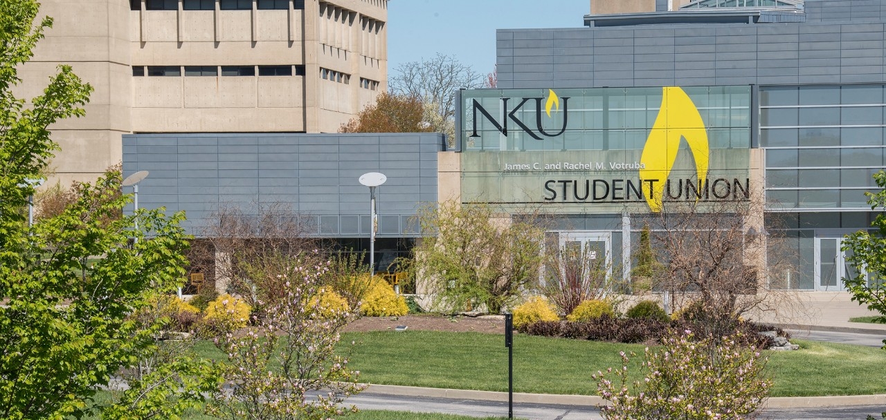 NKU Campus Student Union building in spring with green trees and blue sky.