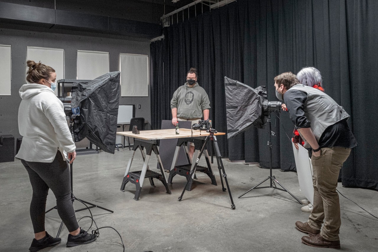 Students photographing objects in the NKU photography studio using lighting equitment  