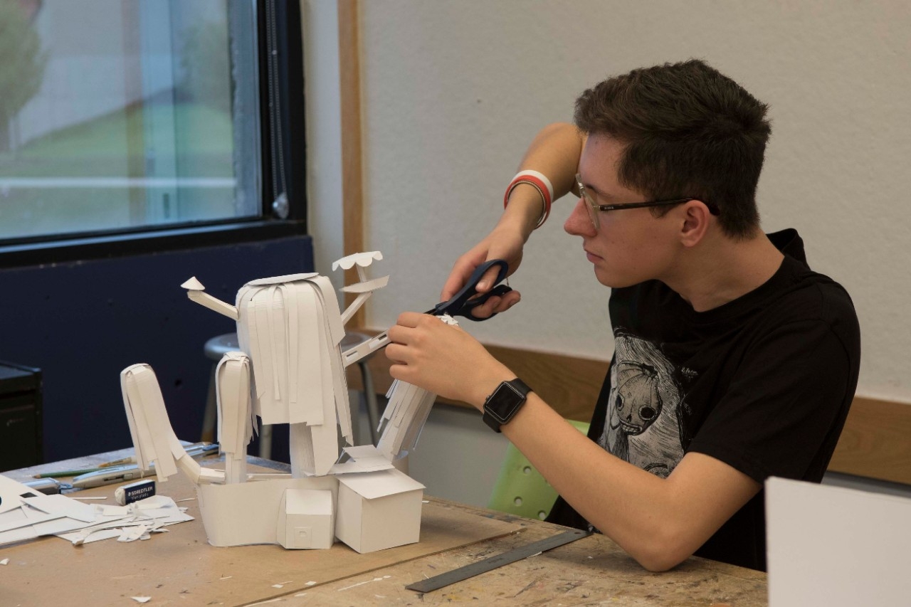 Student creating a paper tree 