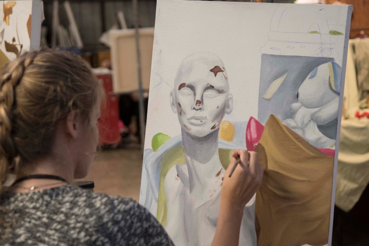 student painting a figure 