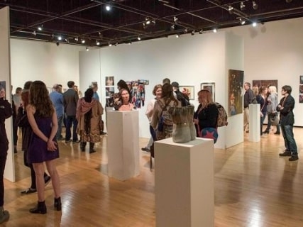 People congregating and observing art in a SOTA Gallery