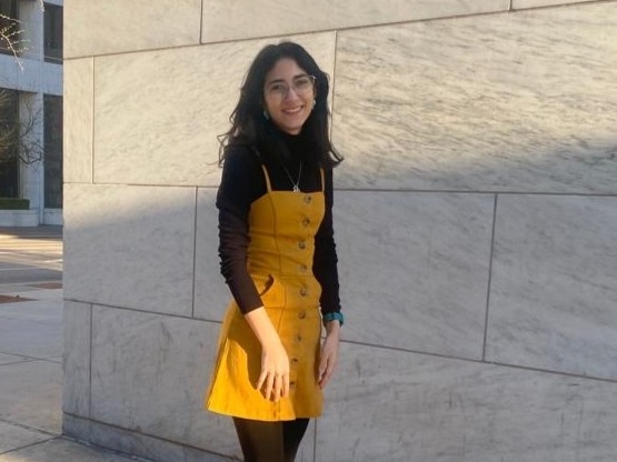Andrea Cárdenas Echavarría smiling outside against a marble wall