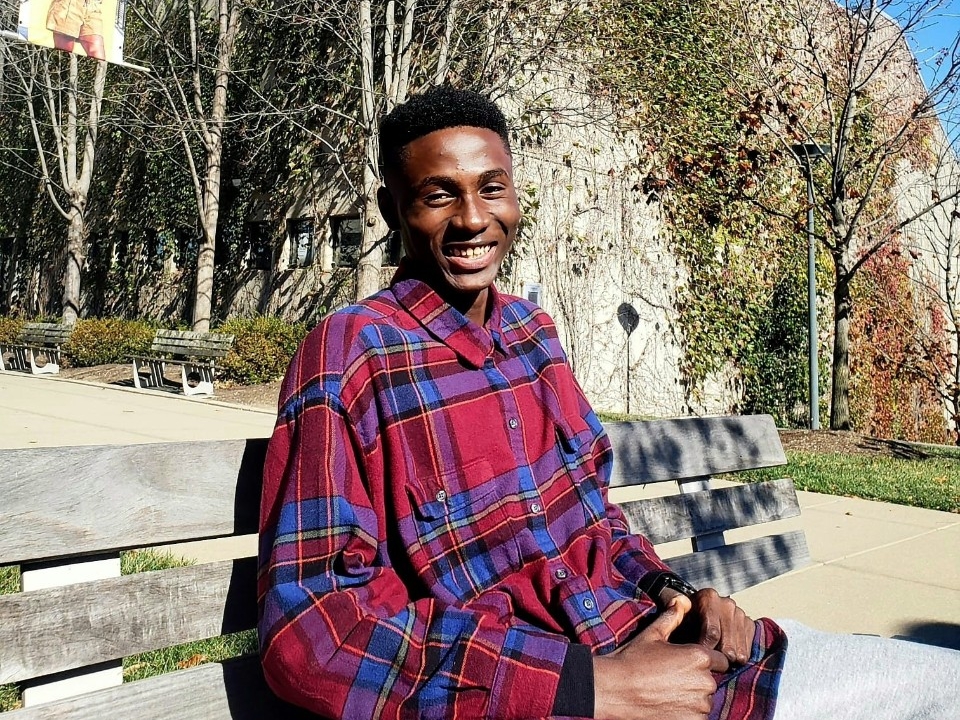 Joshua Osakwe smiling for the camera on campus