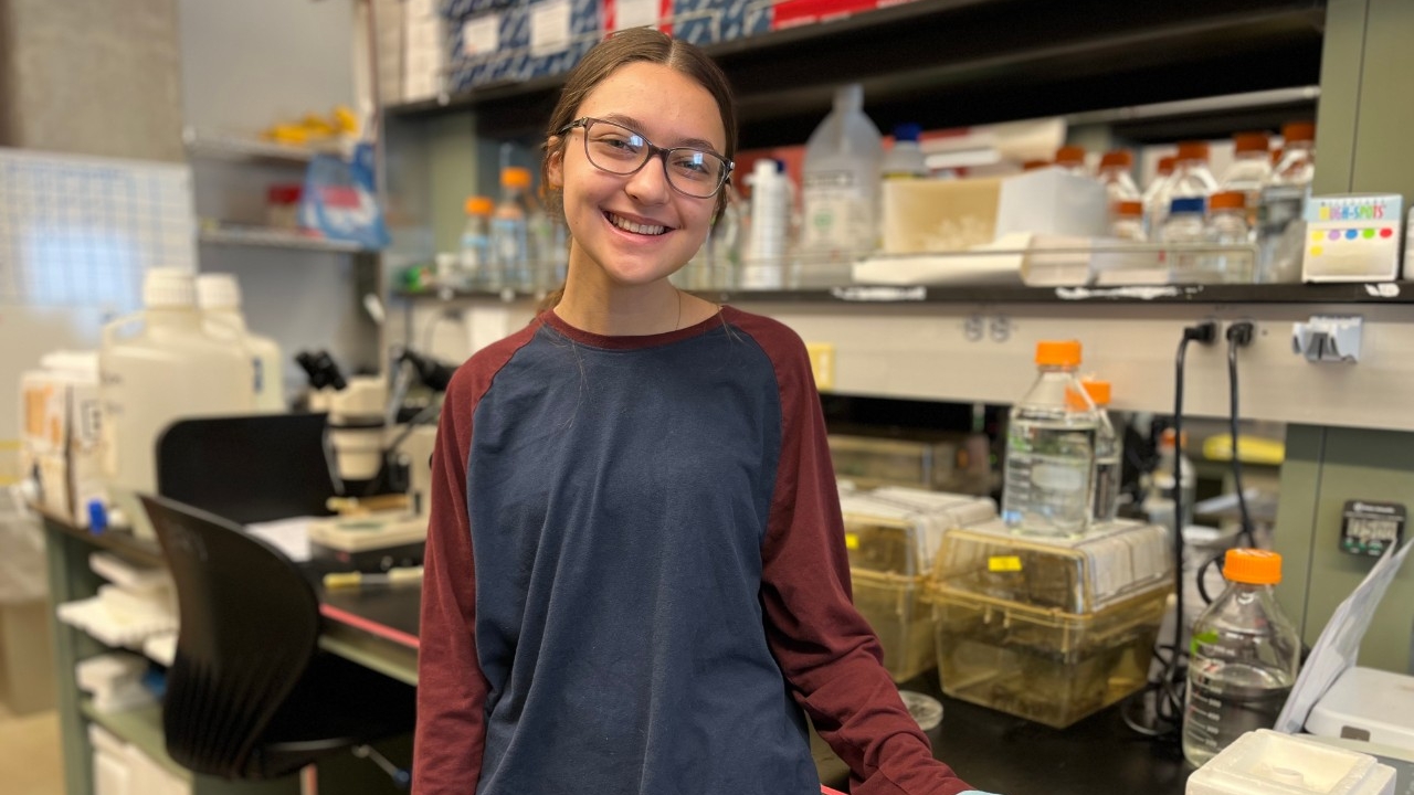 Greaves Scholarship recipient smiles for the camera while doing paid summer research in a biology lab.