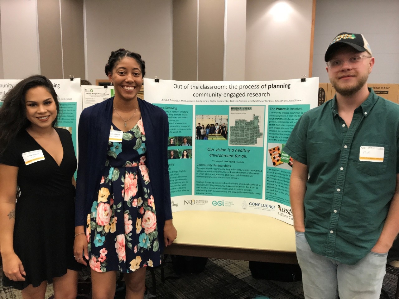 Three Northern Kentucky University STEM majors smile proudly next to their research poster at a student research celebration event