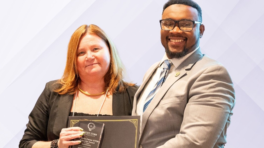 Award-winning educators smile for the camera with their awards