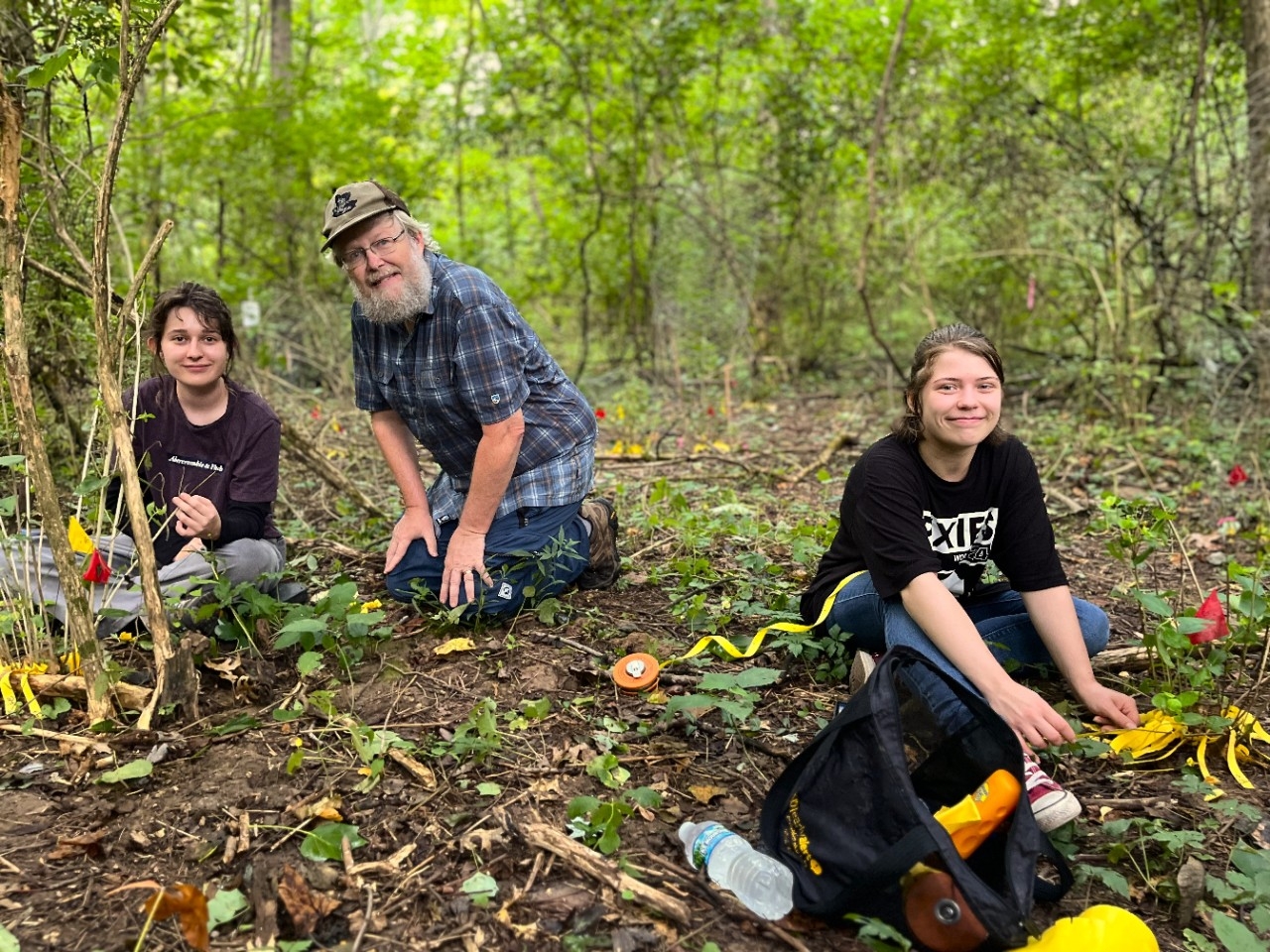 Two NKU undergraduate students do research with a faculty member in the woodlands of NKU REFS.