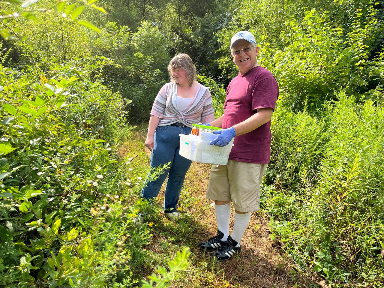 NKU Biology faculty and student collect samples in the woodlands of REFS.