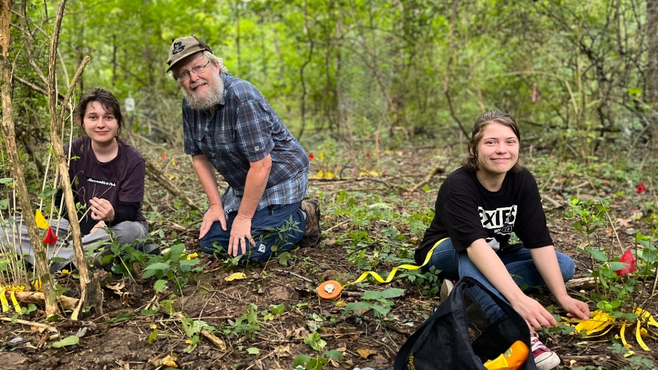 NKU Biology faculty works in the woods with research students.