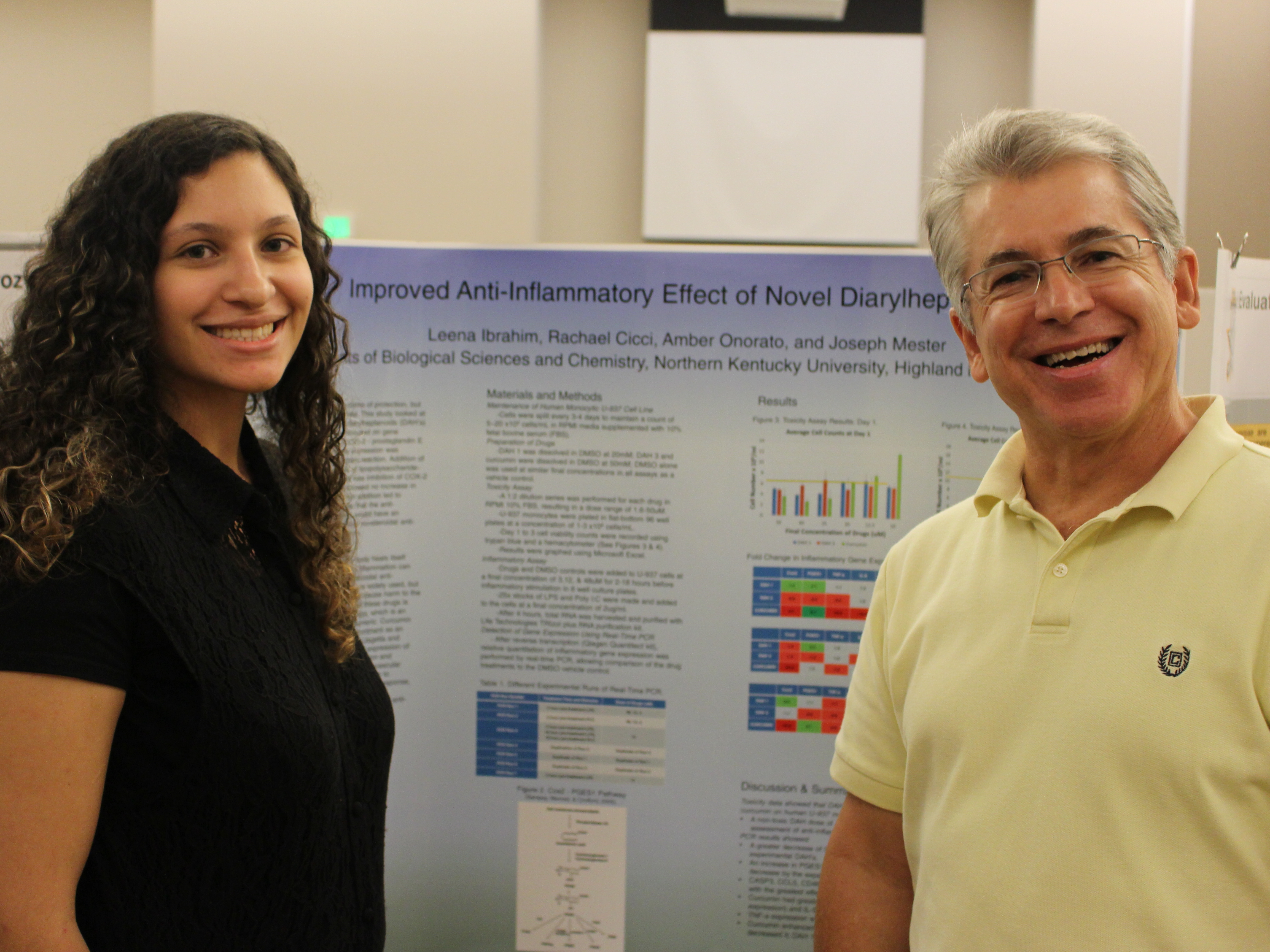 Photo of Dr. Mester with a student and her tri-fold presentation board. 