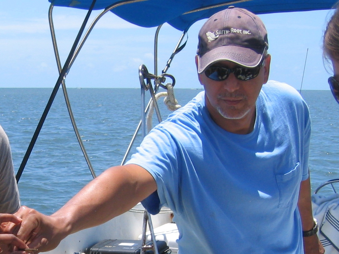 Photo of Dr. Acosta on a boat out on the water. It is a sunny day and he is wearing sunglasses.