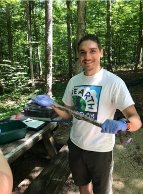 Oliver Diaz conducts field research in the woods.
