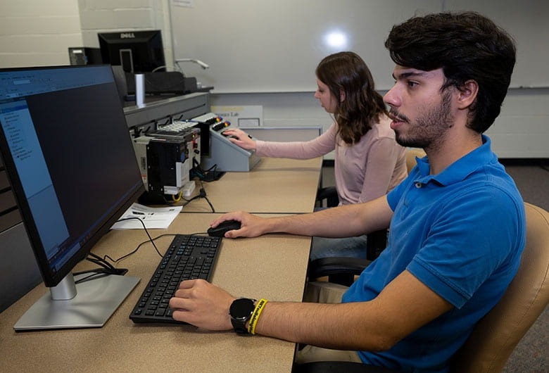 Student working at a computer station inside classroom