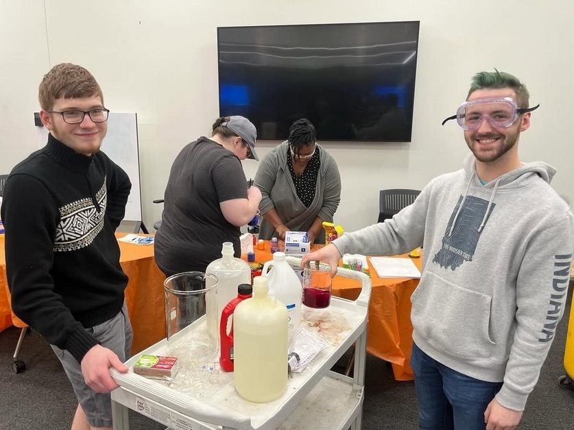 Club members smile as they prepare chemistry supplies for a demonstration.