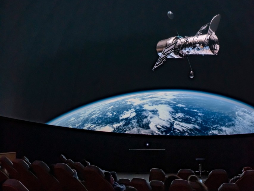 The planetarium screen features a colorful, starry, nebula