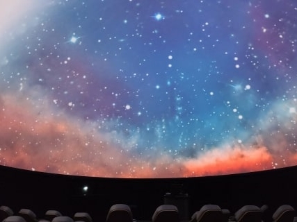 The planetarium screen features a colorful, starry, nebula