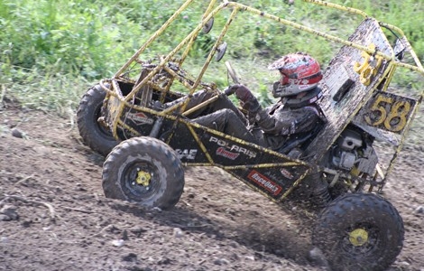 A student driving the Baja vehicle on a dirt path