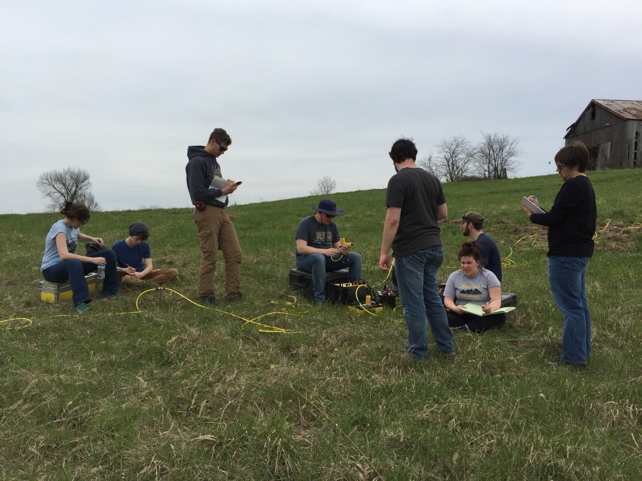 Students using geophysical equipment in a field