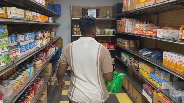 student walking through aisle of food at NKU FUEL pantry