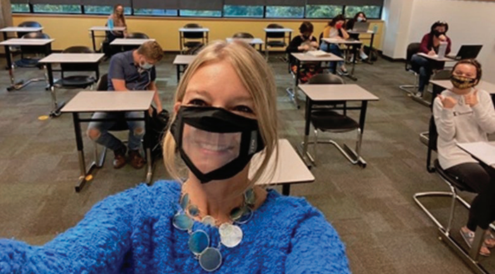 Photo of teacher in classroom wearing a see-through face mask