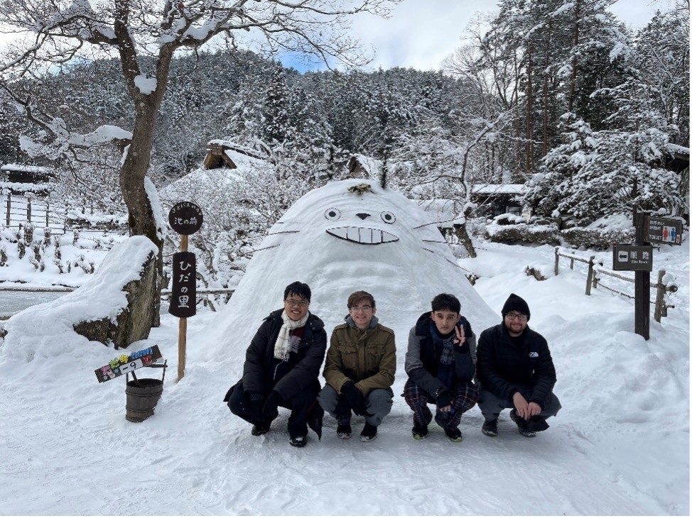 Study abroad students in Japan, standing in the snow next to a snow sculpture