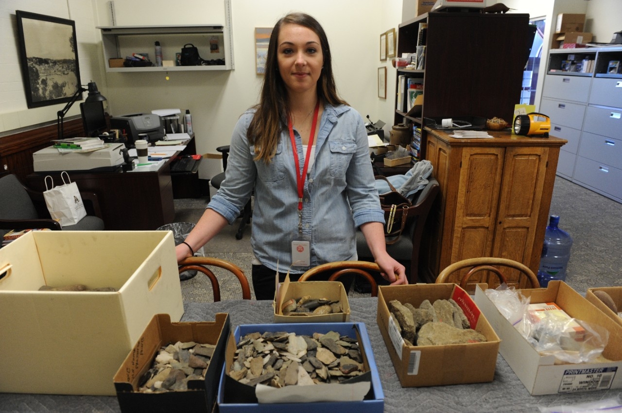 Student working at a table filled with excavation samples