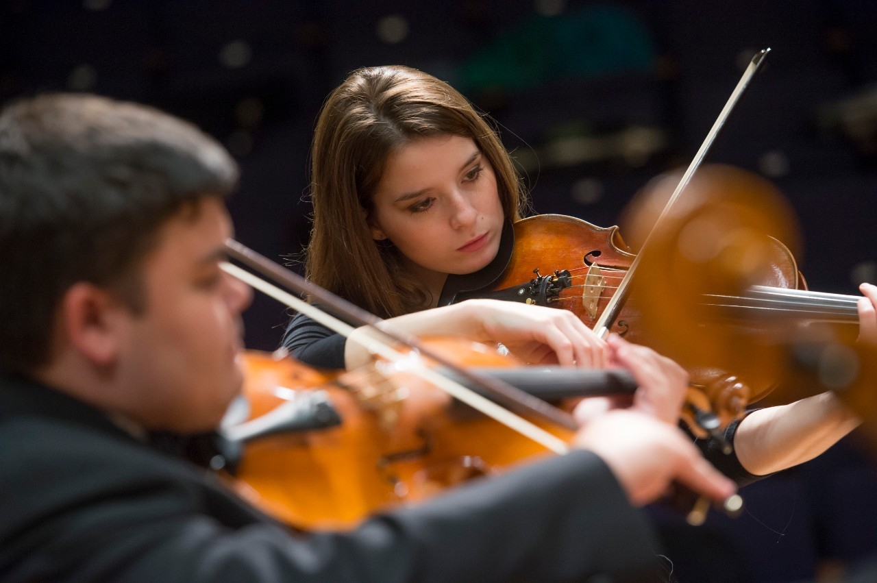 Students playing the violin during a performance