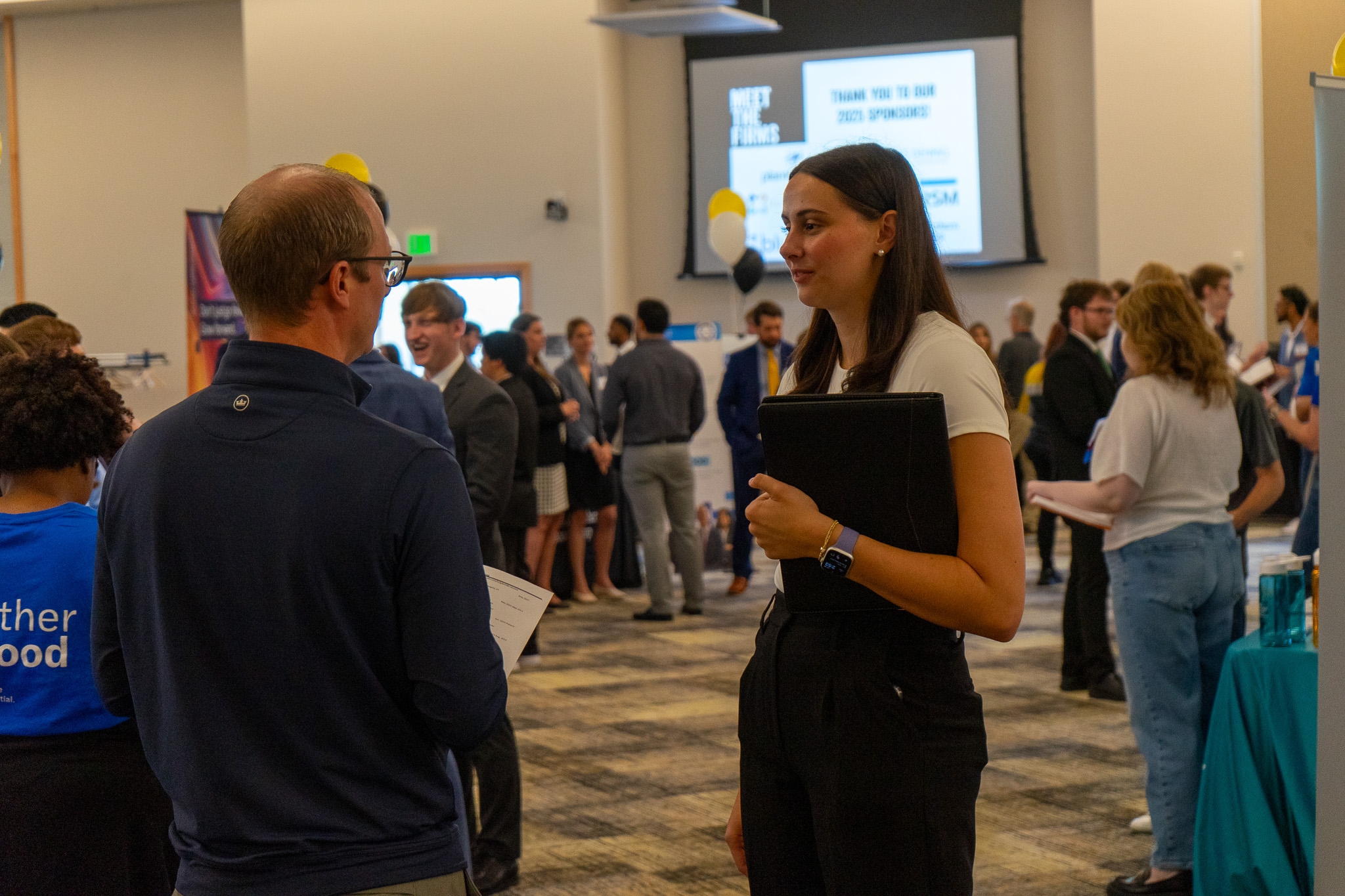 image of a young accounting student speaking with a recruiter at a job fair for accounting majors called Meet the Firms