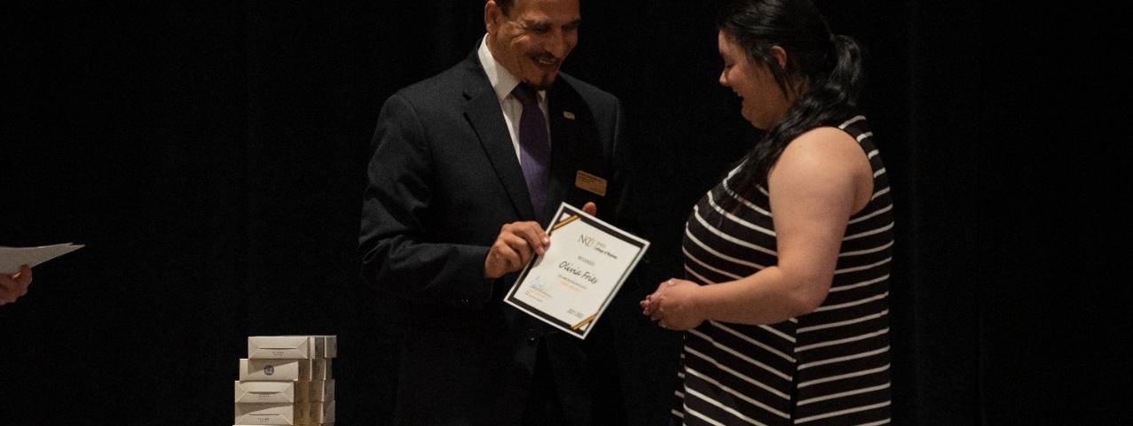 Student being presented an award by Dean Hassan R HassabElnaby at the 2022 luncheon.