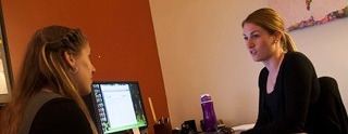 Advisor speaking with a student in an office.
