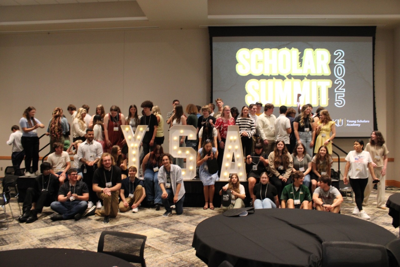 group of students posing with "YSA" light up letters