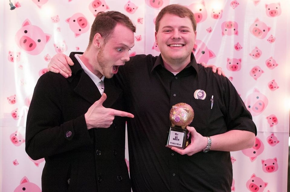 Image of two male OINK film festival participants holding a trophy with their arms around each other.
