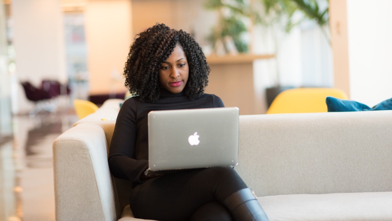 Black female student at her desktop in a common area 