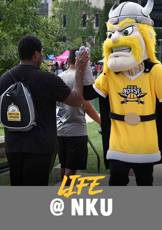 Life at NKU: Student at an event giving Victor E. Viking a high-five