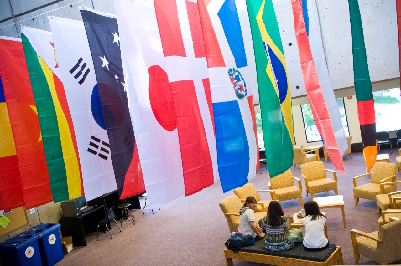 International flags hanging from ceiling inside room.