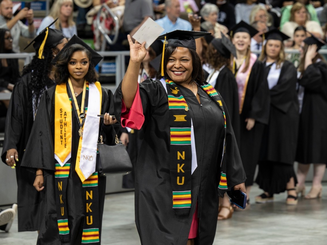 Graduating adult student walking during commencement