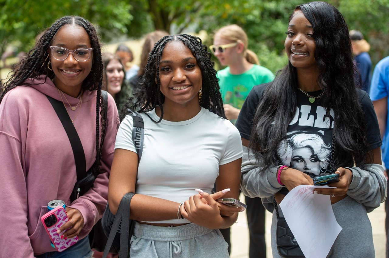 Three female students standing together smiling