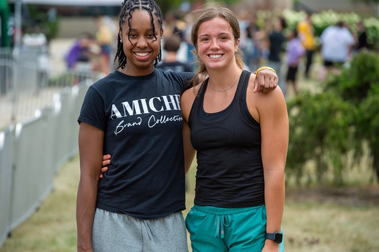 Two female students at Victorfest, one arm around the other's shoulder..