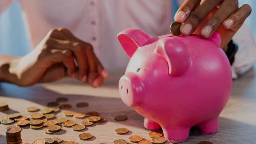 A person putting coins into a piggy bank