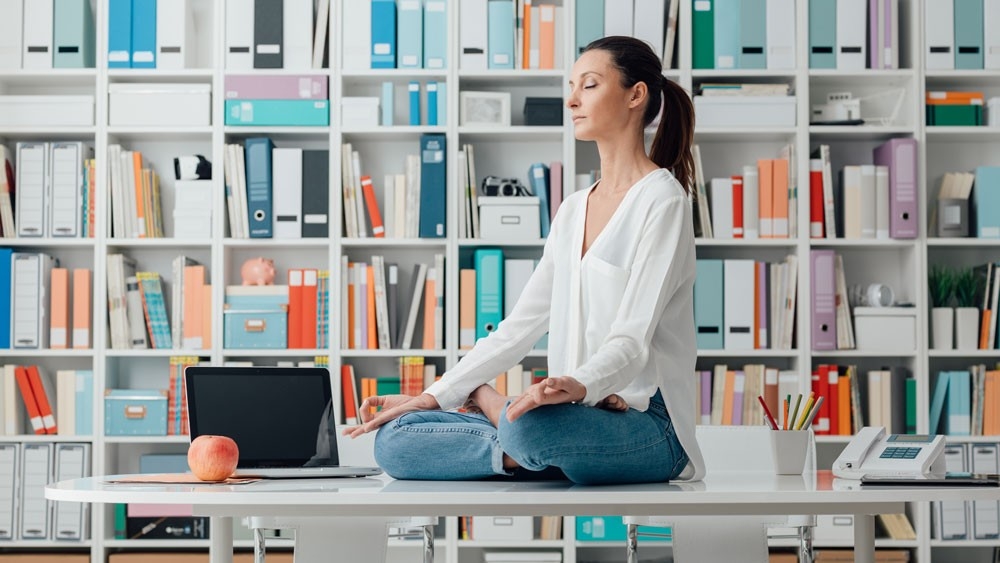 Woman sitting on a desk meditating