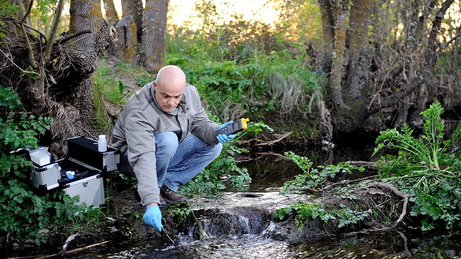 A technician analyses water in a stream