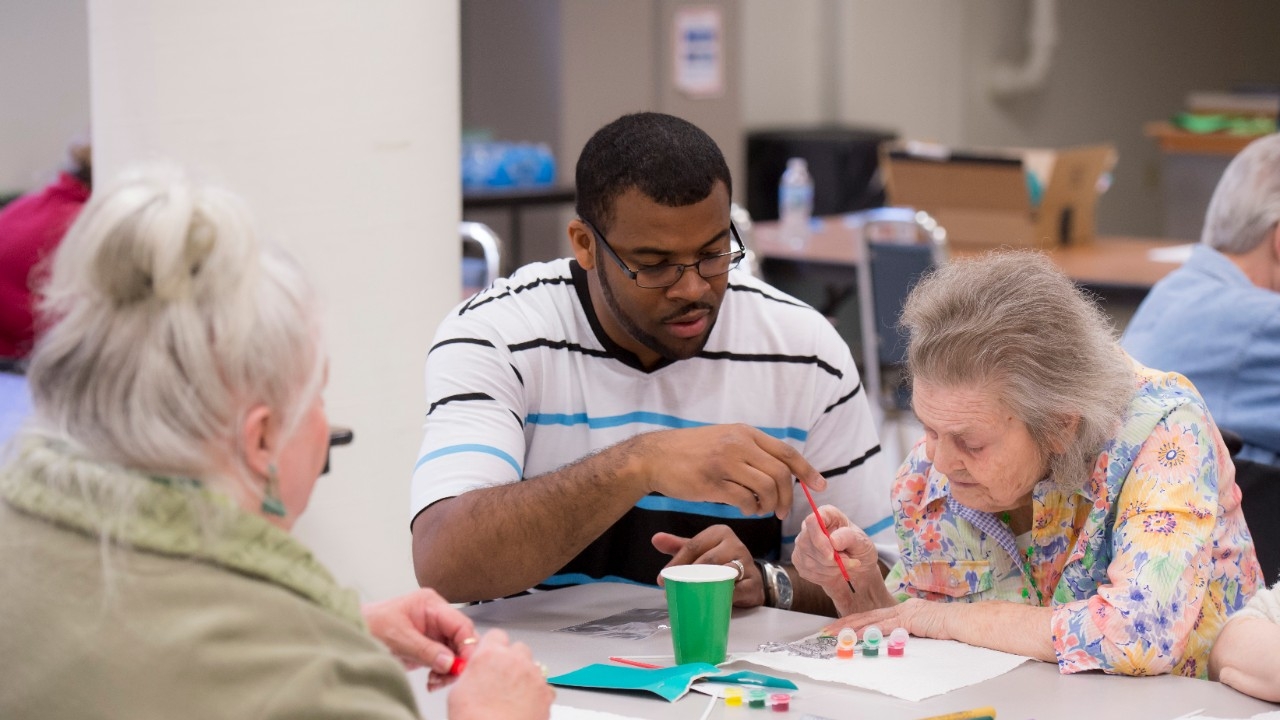 Nursing home residents and counselor working on crafts