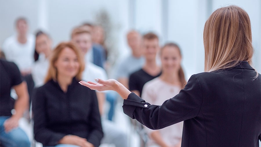 Woman speaking before a group of people