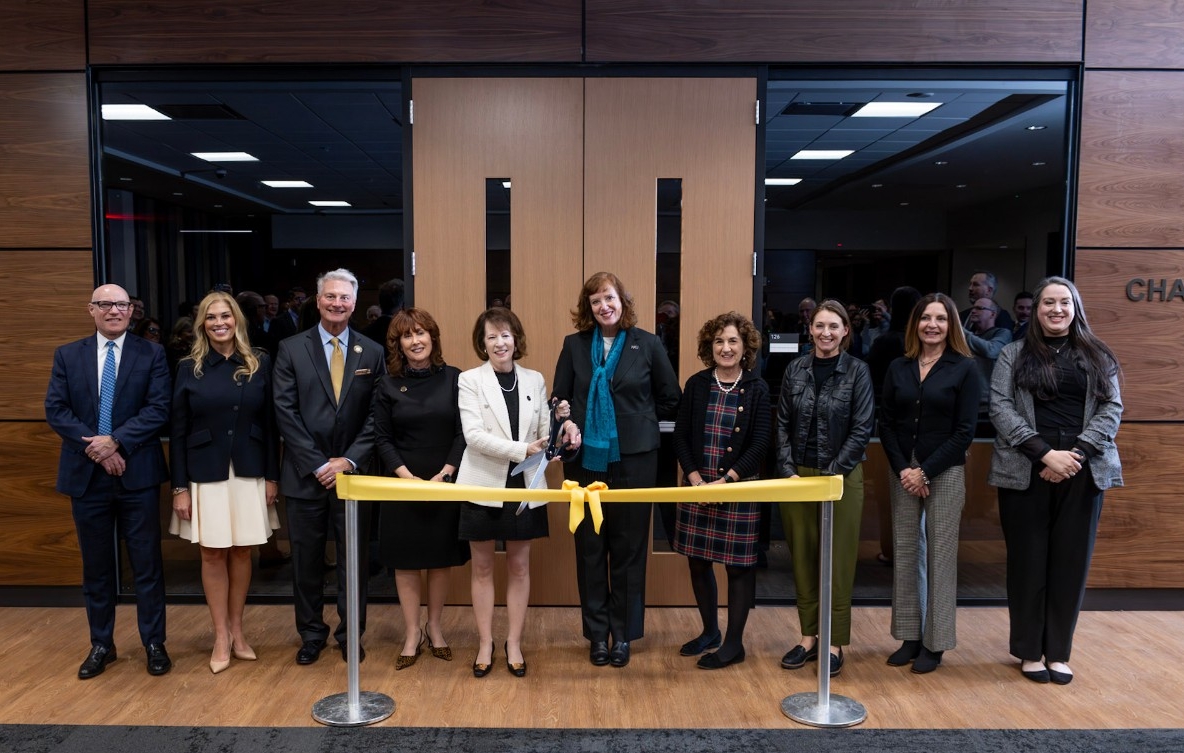 President Cady Short-Thompson and Chase Law Dean Dr. Judy Daar hold large scissors near a yellow ribbon in front of the new Chase College of Law courtroom.