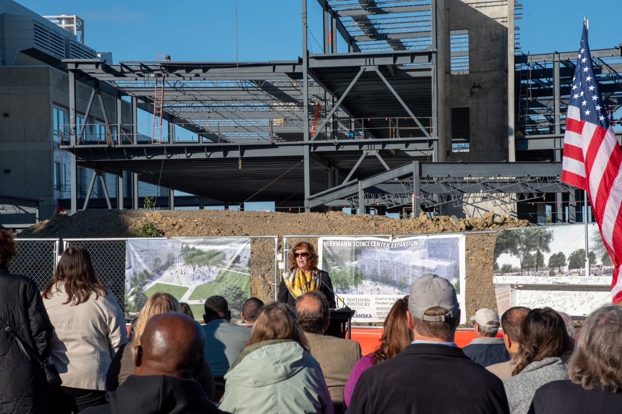 NKu President Cady Short Thompson speaks to crowd in front of ongoing Science Center expansion during topping out ceremony. 