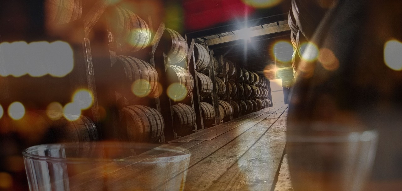 Bourbon barrels in background with bottle in foreground