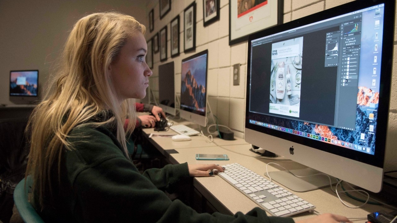 Student reviewing designs on a computer monitor
