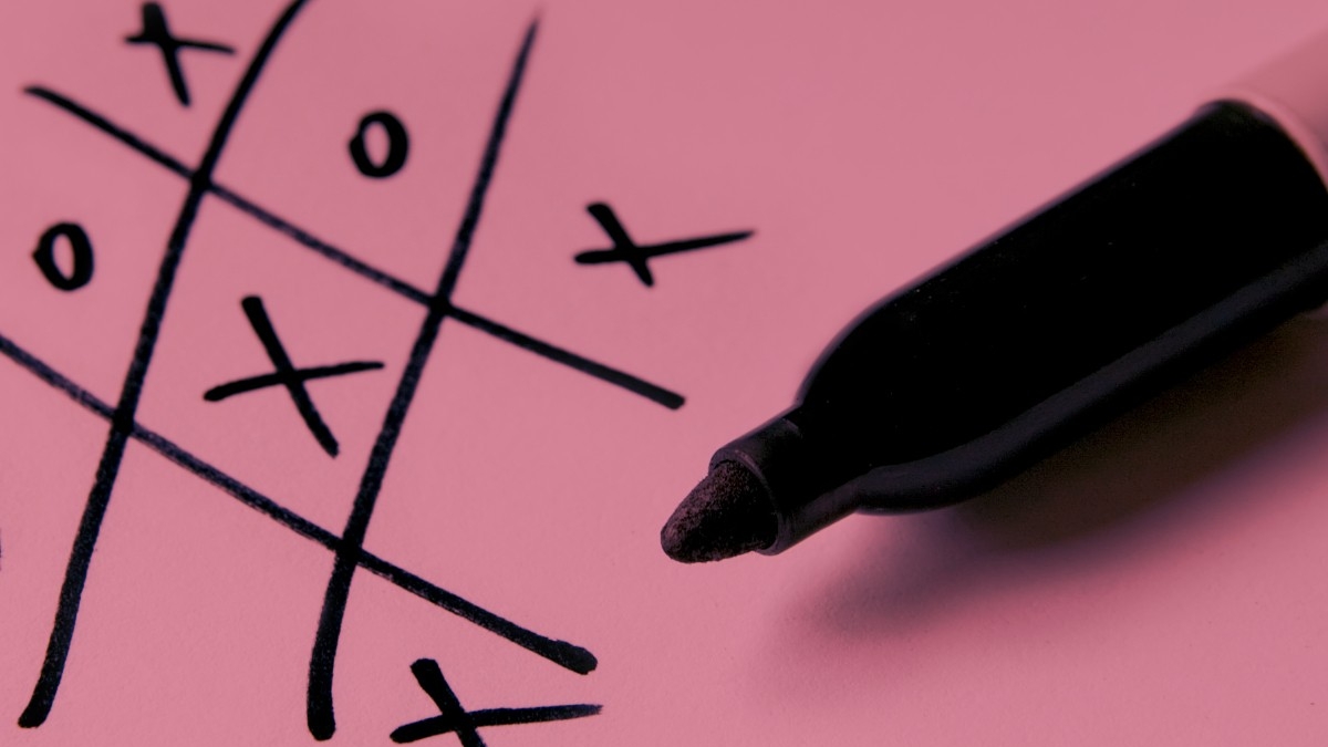 a pen on paper with tic-tac-toe drawn on it